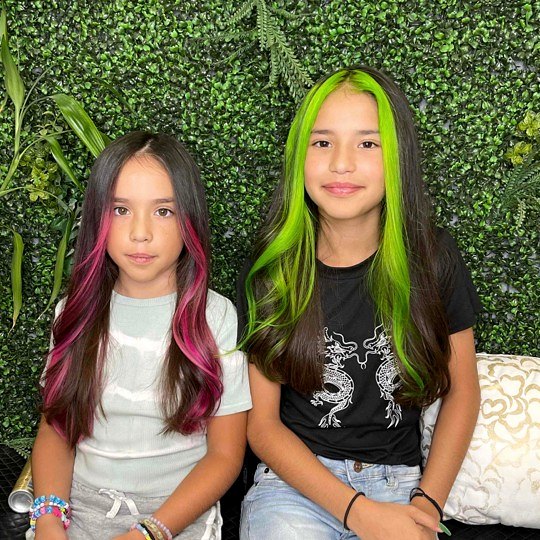 Two girls with pink and lime green face-framing streaks